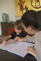 Enfant lisant ses premiers mots avec la méthode syllabique